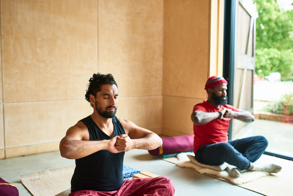 Multi-ethnic group in yoga studio during a yoga session, hands clenched, strength, concentration, determination