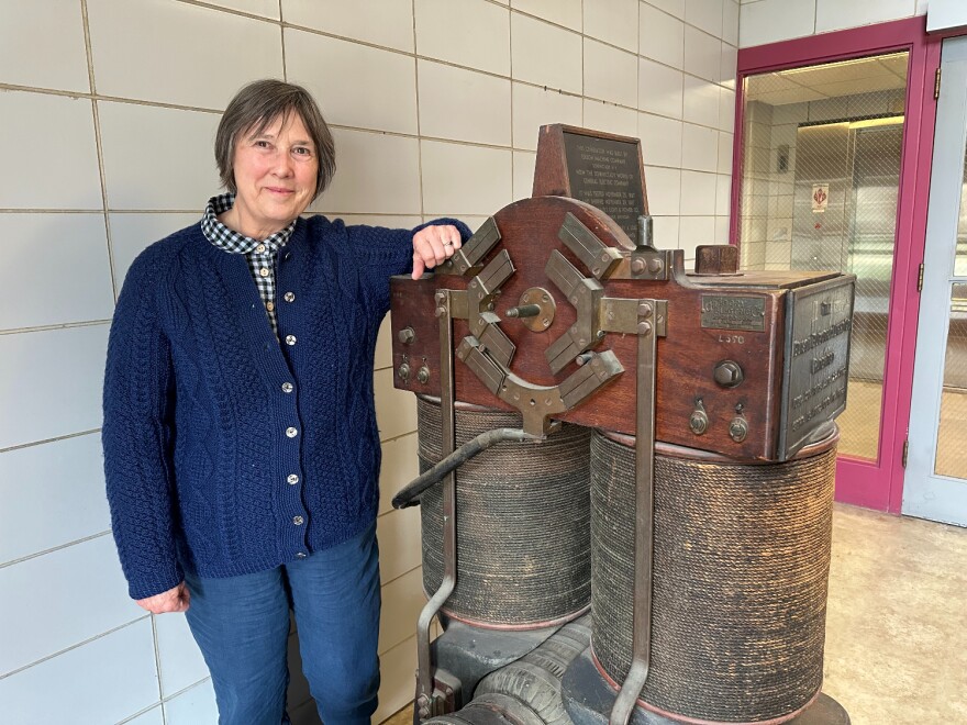 Anne Kimber, executive director of the Electric Power Research Center at Iowa State University shows off a generator built in 1887.